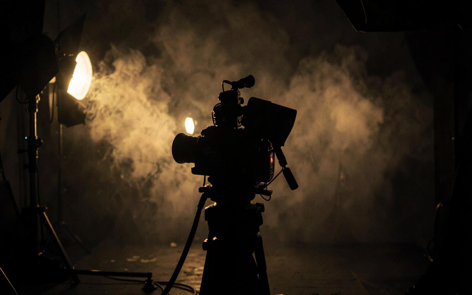 Film crew and cinema camera on a smoke-filled commercial set